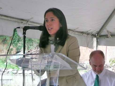 Priscilla Almodovar, President and Chief Executive Officer of the NYS Housing Finance Agency, speaks at the groundbreaking at the Cedar Avenue Apartments in the Bronx. Steve Coe, CEO of Community Access, is seated to the right.